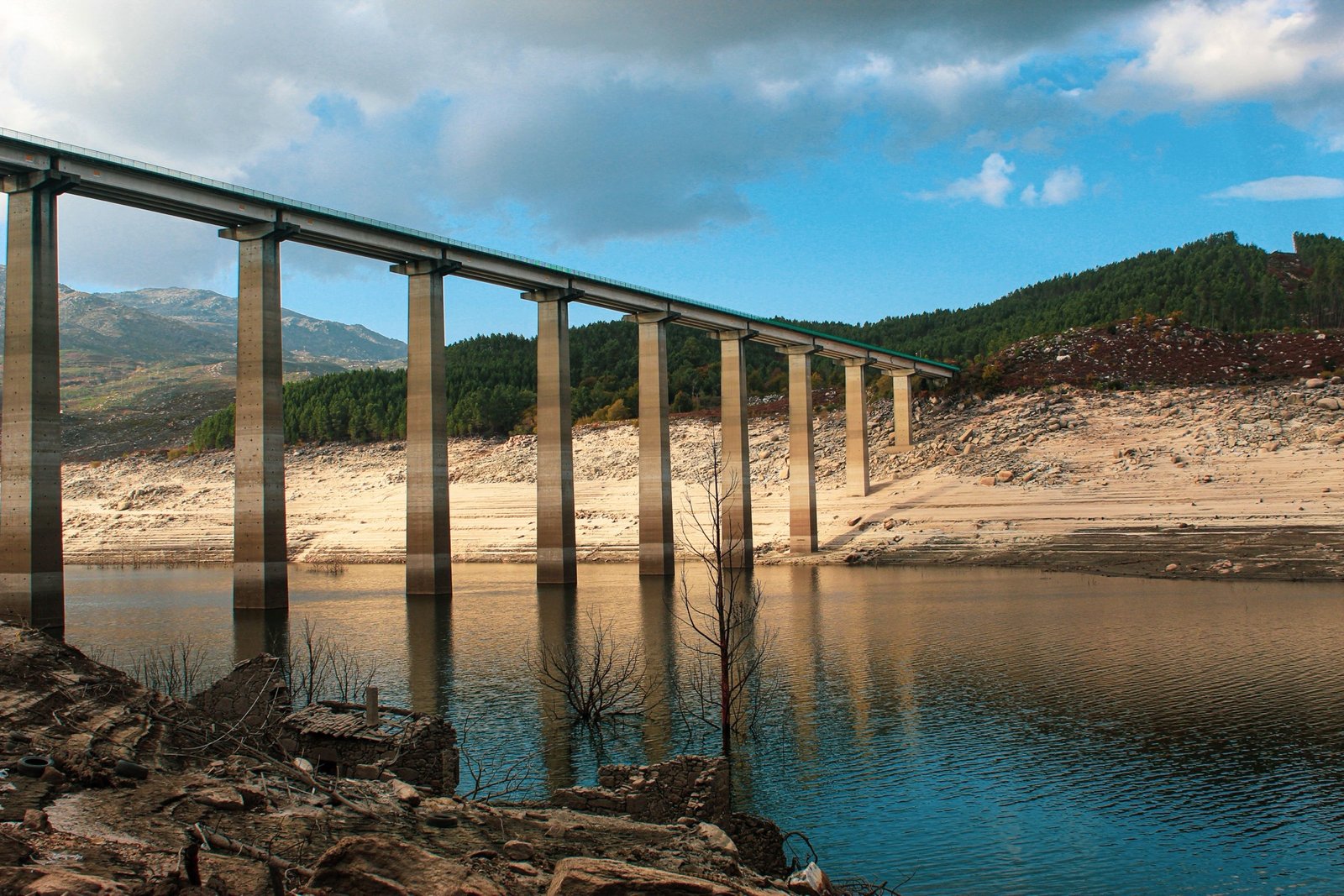 Embalse con el nivel de agua muy bajo bajo un viaducto